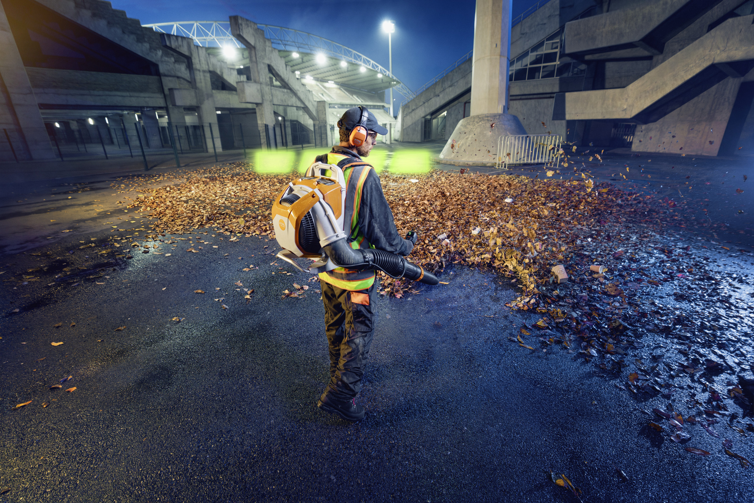A man is blowing wet leaves off the tarmac with the BRA 600 