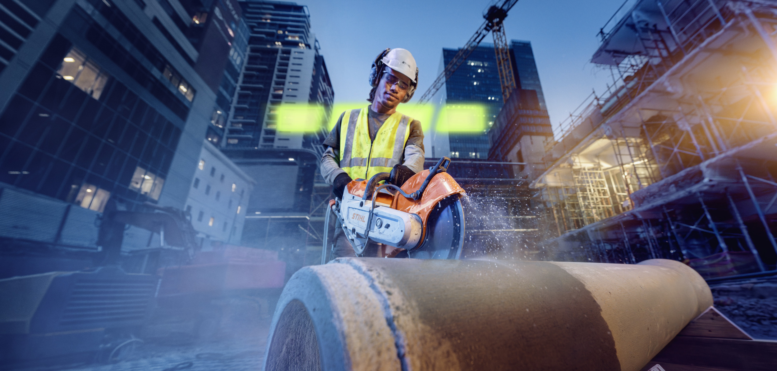 A man is cutting a concrete pipe with the TSA 350 cordless angle grinder