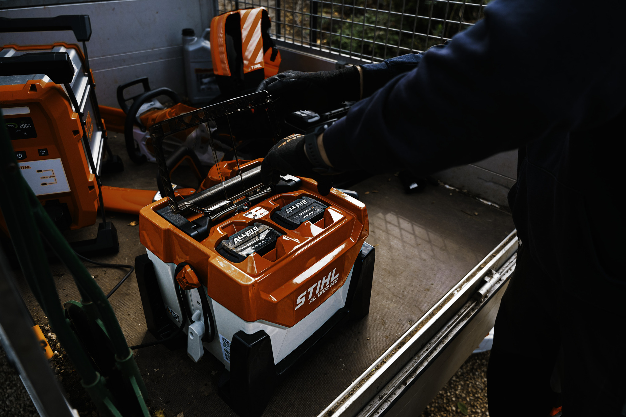 A man plugging an ALLPRO battery into a high-speed charger