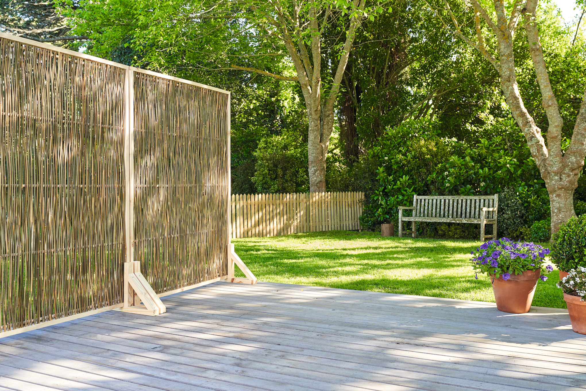 DIY outdoor privacy screen made from wood on a wooden terrace