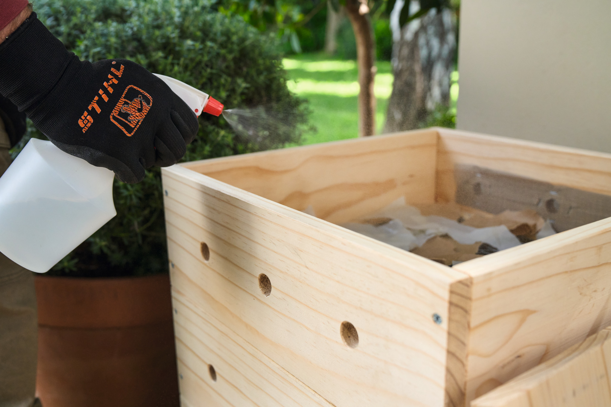 Someone moistens the paper scraps with a water mister