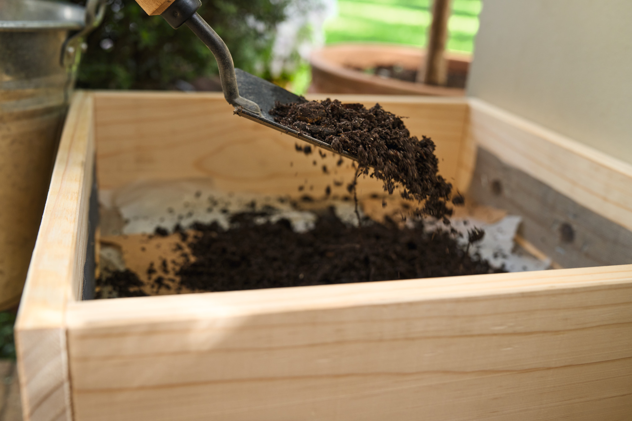 A man shovels soil onto the paper scraps