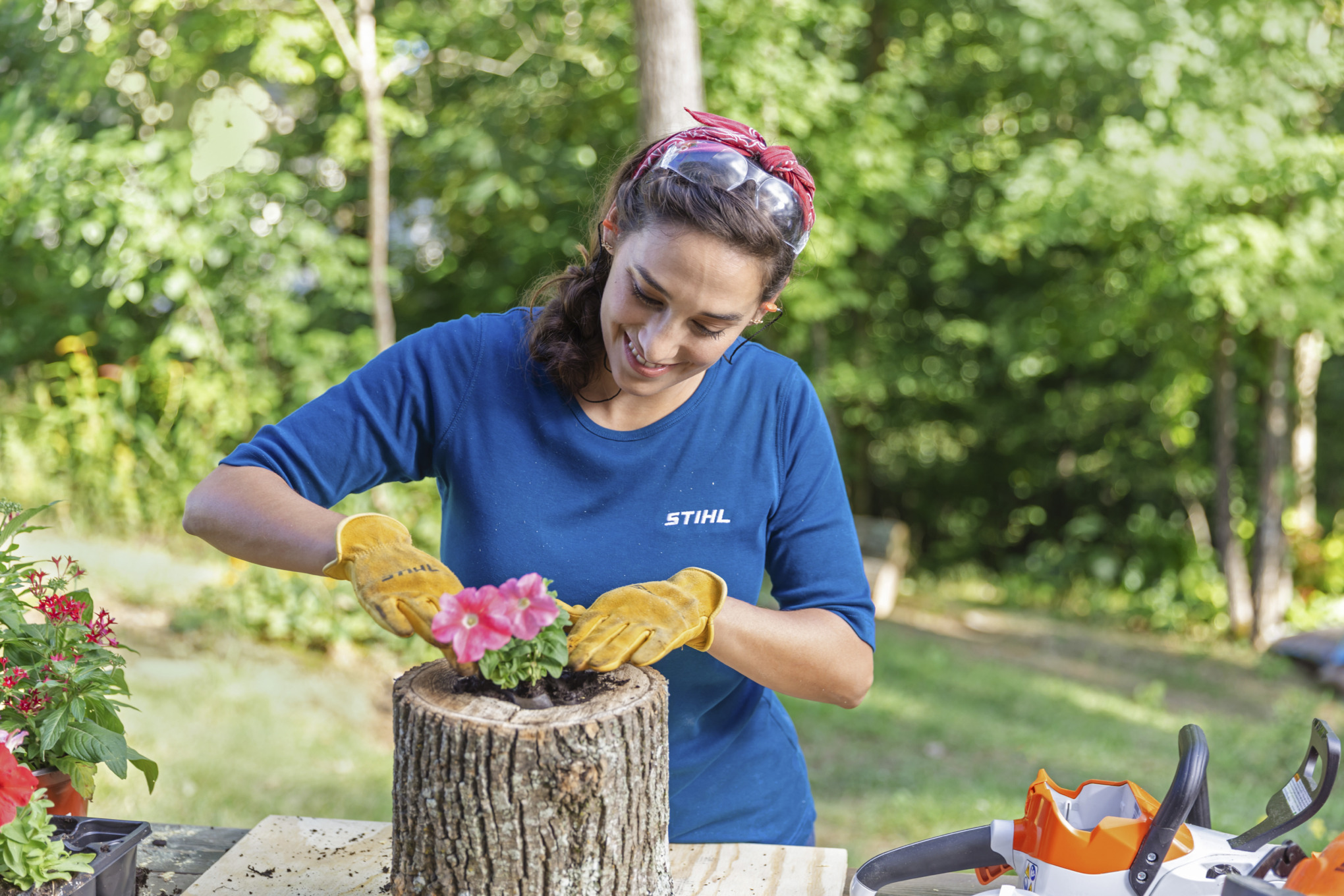 Sara Bendrick planting flower in log planter