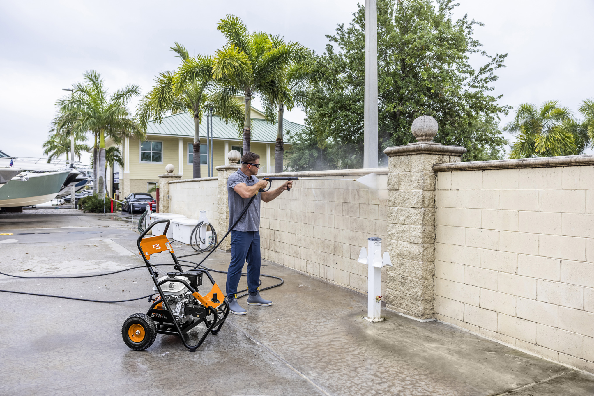Man Using STIHL Pressure Washer to Clean Brick Wall