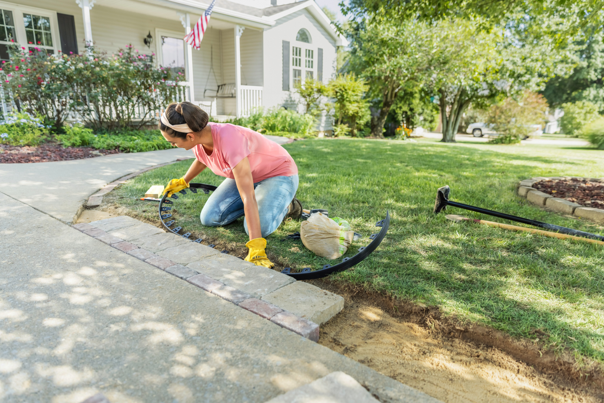 Sara Bendrick laying plastic paver edge to secure pavers.