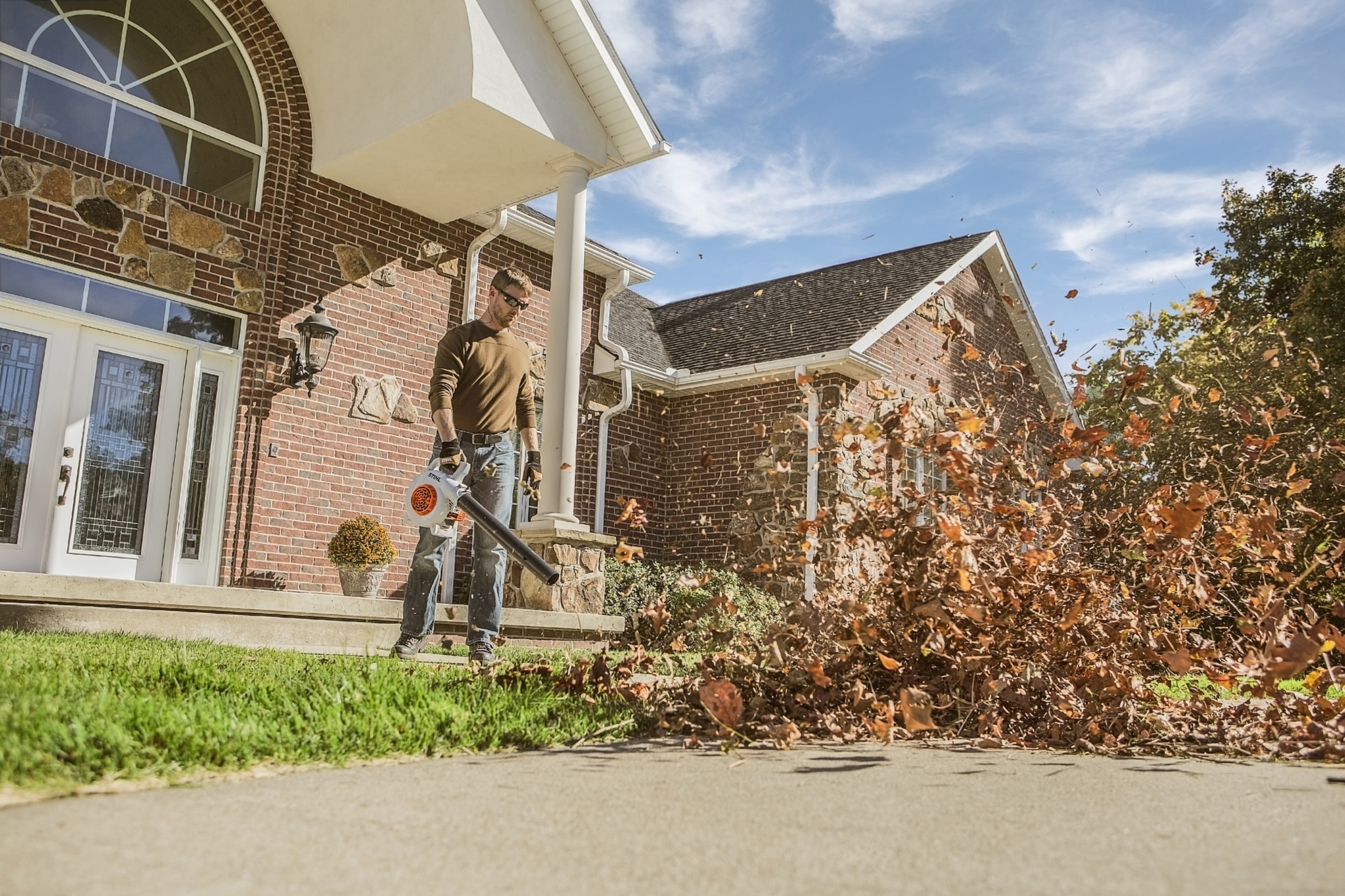 Man using STIHL BG 50 to blowe leaves off sidewalk
