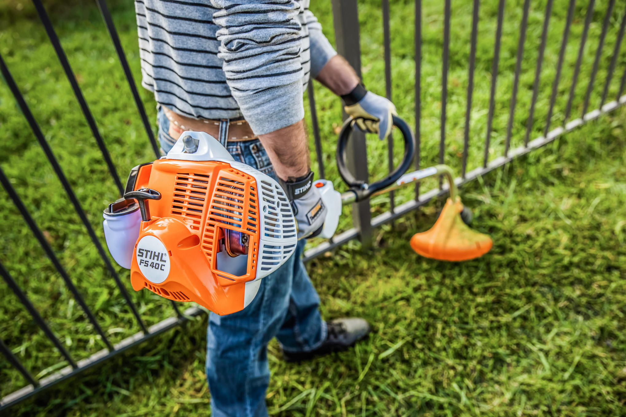 Man Using STIHL FS 40 C-E to Trim Around His Fence