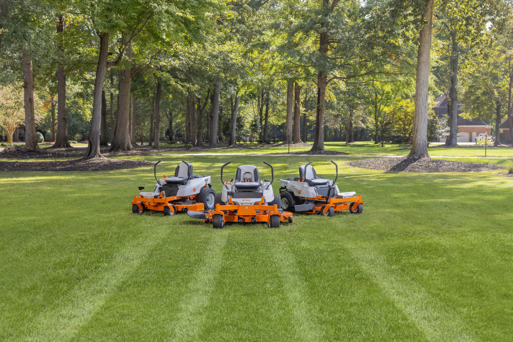 Three STIHL Zero-Turn Mowers in a yard