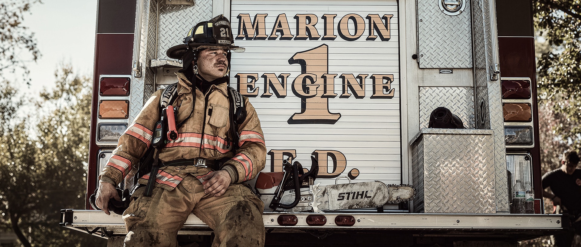 Firefighter sits on back of firetruck with STIHL MS 462 R C-M rescue saw