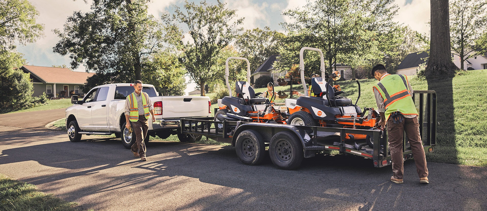 landscapers near trailer with two STIHL zero-turn mowers