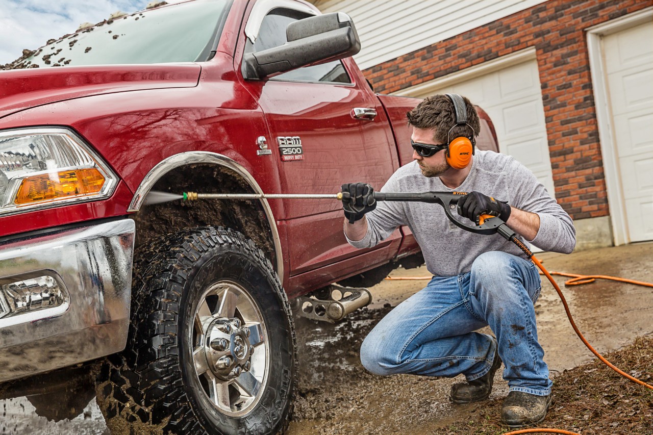 Man using a STIHL pressure washer to clean a truck