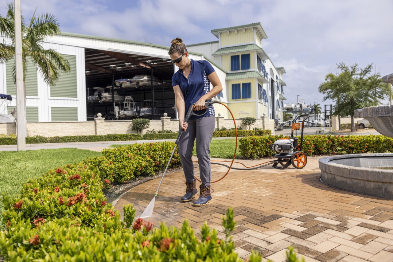 Woman using a STIHL RB 200 Pressure Washer to clean a patio