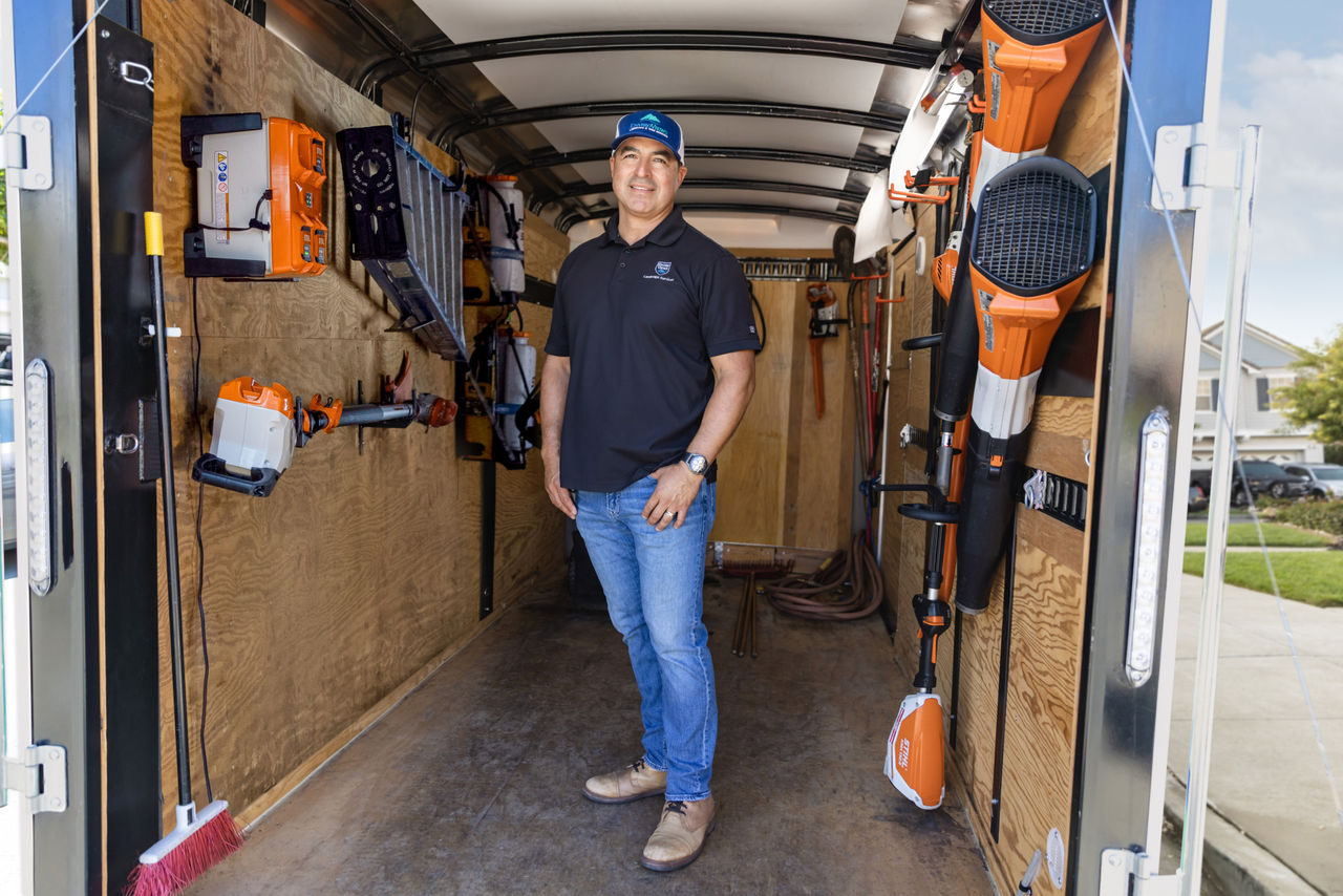 Professional Landscaper, Armando, Standing in a Work Trailer