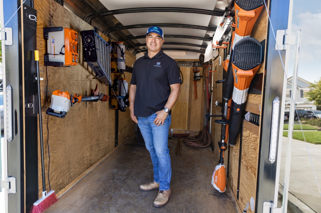 Professional Landscaper, Armando, Standing in a Work Trailer