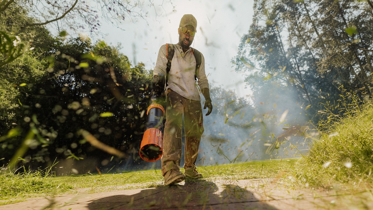 STIHL battery-powered leaf blower clearing debris along a driveway