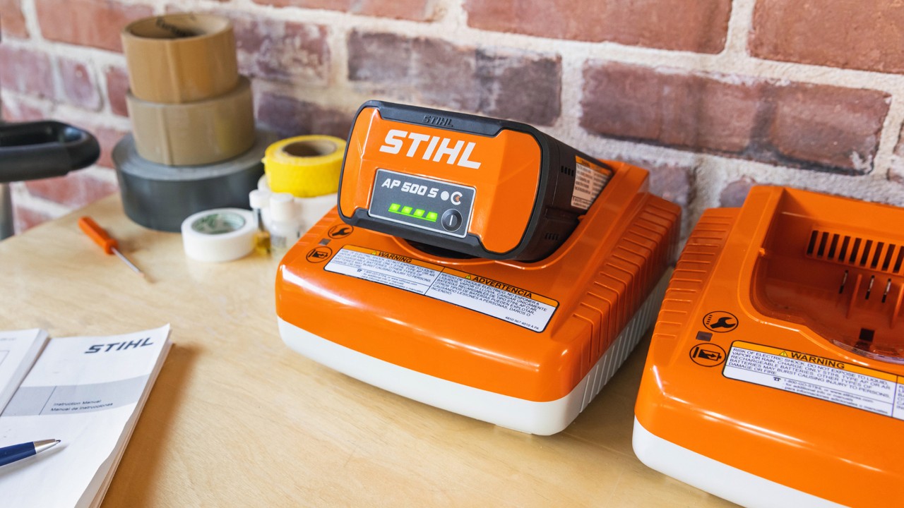STIHL battery and charger system displayed on a countertop with charging indicators