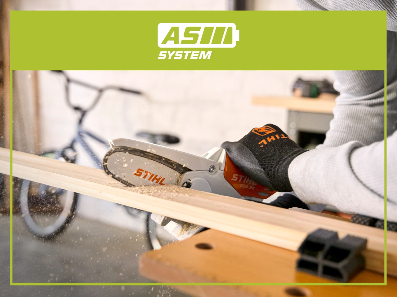STIHL AS System compact battery-powered chainsaw cutting wood on a workbench