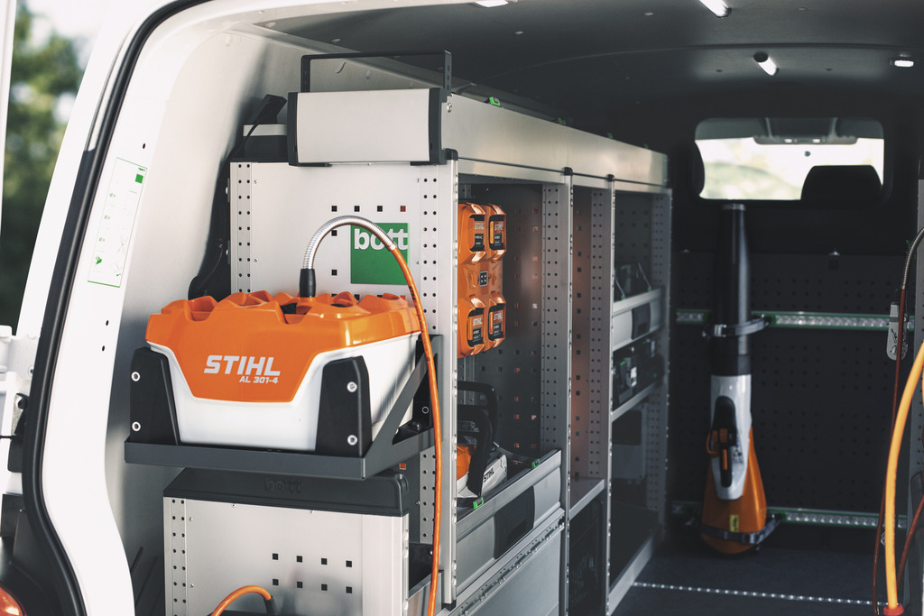 STIHL mobile charging system with organized battery storage and charging stations inside a service van.