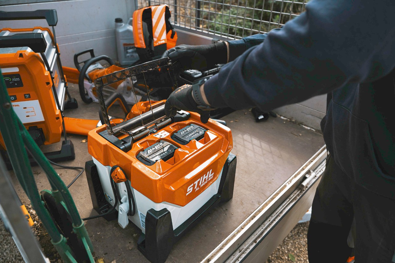 STIHL batteries charging at a mobile jobsite charging station inside a service vehicle.